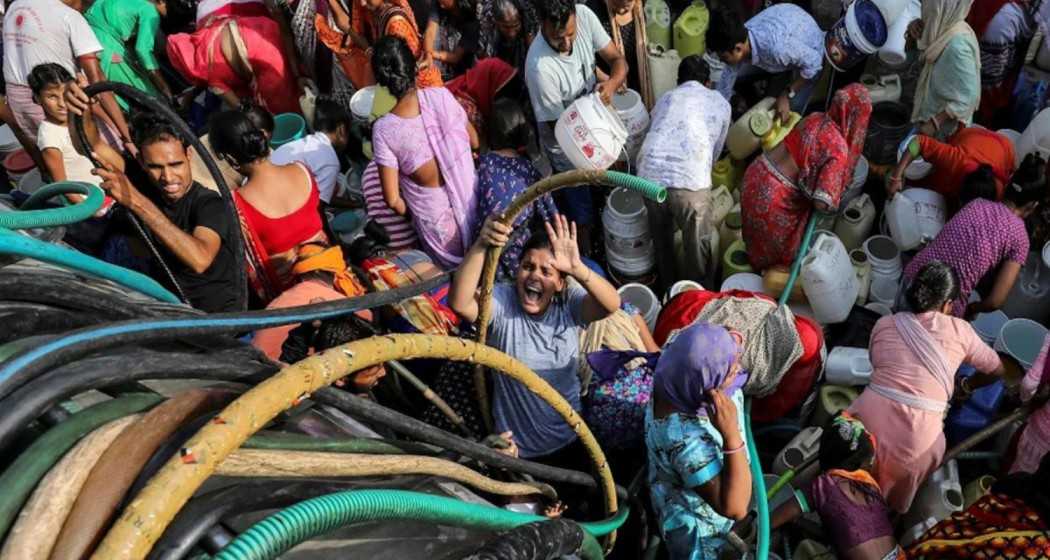 Residents collect drinking water from a tanker amid ongoing water crisis in a locality in the national capital.