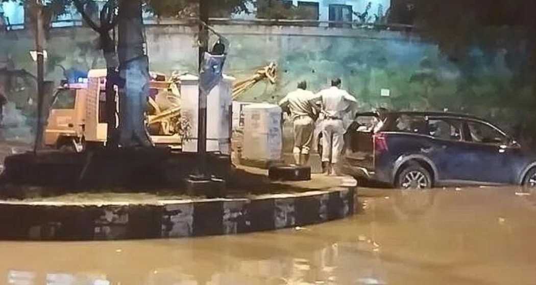 Police inspect the flooded area as they attempt to tow the SUV where the tragic incident occurred.