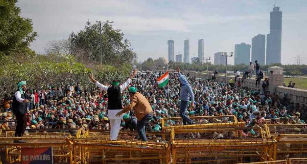 Farmers climb a police barricade during a protest demanding a hike in land compensation and better rehabilitation facilities for their families, in Noida on the outskirts of New Delhi.