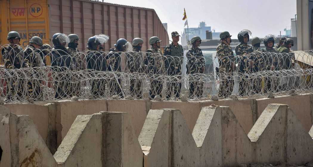 Security personnel stand guard during the protesting farmers Delhi Chalo March, at the Tikri Border, in New Delhi, Wednesday.