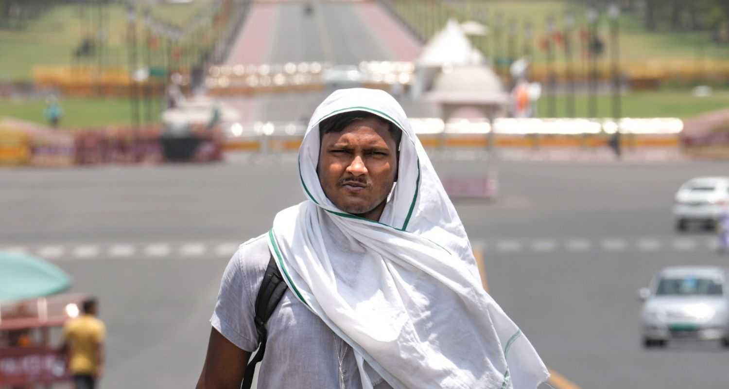 A man covers his head for protection from the scorching sun on a hot summer day, in New Delhi, Tuesday, June 18, 2024. The India Meteorological Department (IMD) has issued a 'red' alert because of prevailing heatwave conditions in the national capital.