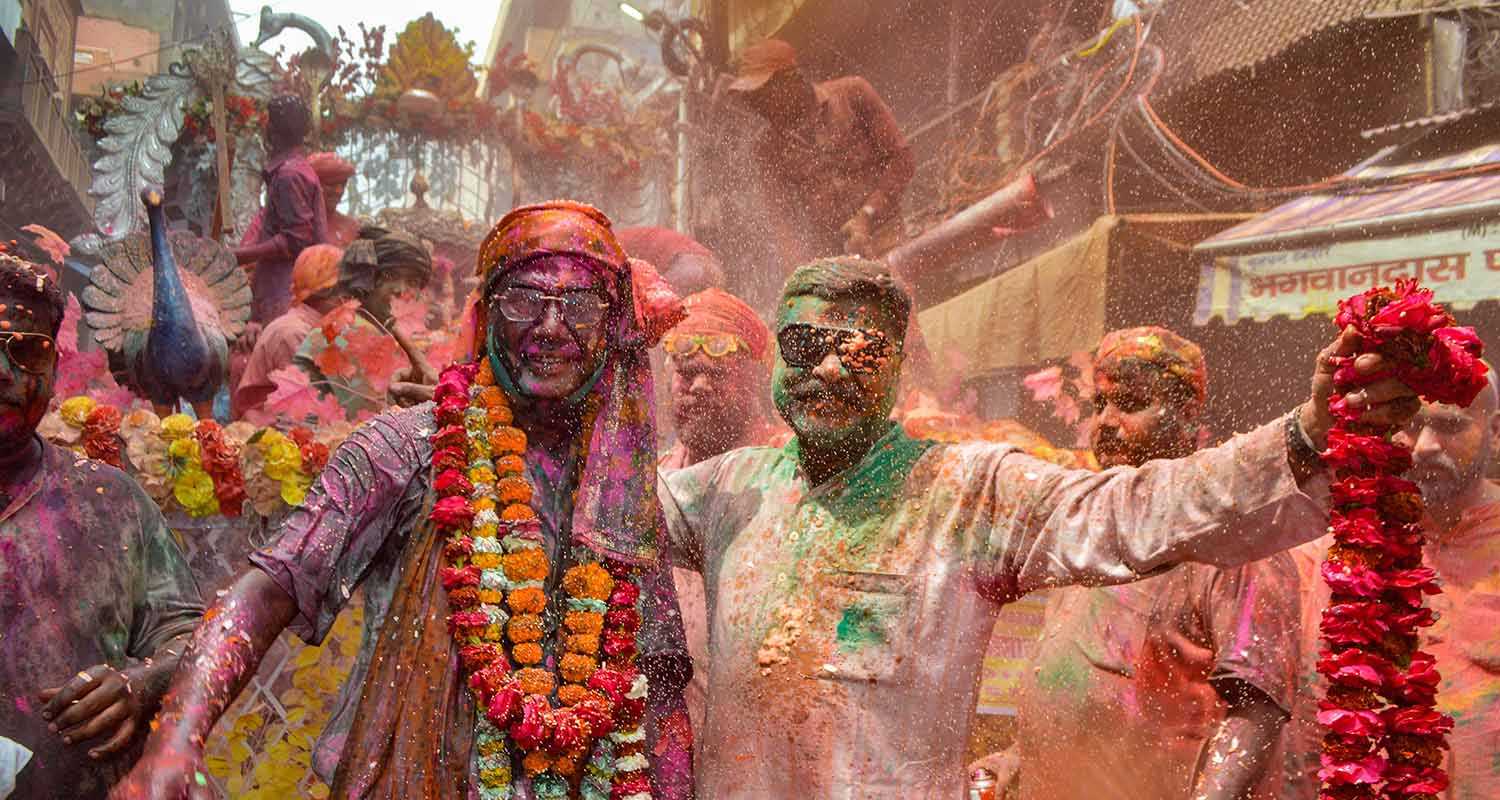 People play with colours ahead of the festival of Holi, in Agra