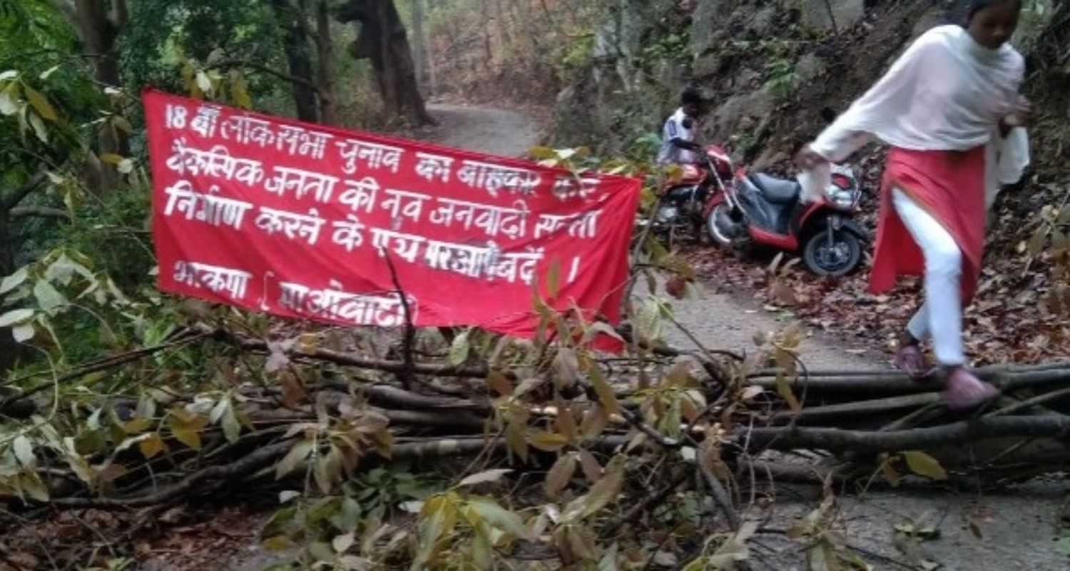 Maoists cut down trees and declare election boycott along rural road in Saranda forest.