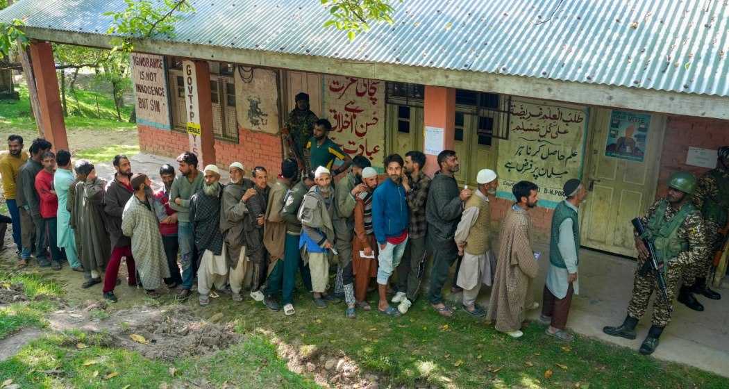 People wait in a queue to cast their votes at a polling booth during the sixth phase of Lok Sabha elections, at Noorbabad area in Kulgam district of South Kashmir on Saturday, May 25, 2024.