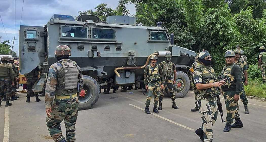 Security forces personnel stand guard after local women tried to march towards Tuibuong, the mass burial site of the Kuki-Zomi people, in Bishnupur district