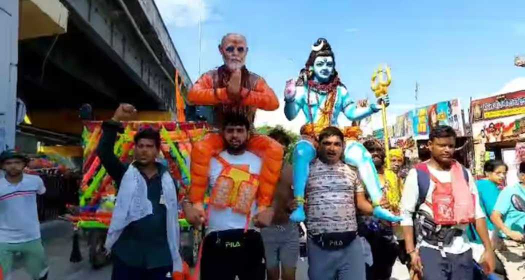 Kanwariya Rupendra Tomar carries a statue of Prime Minister Modi on his shoulders during his pilgrimage from Baghpat to Haridwar.