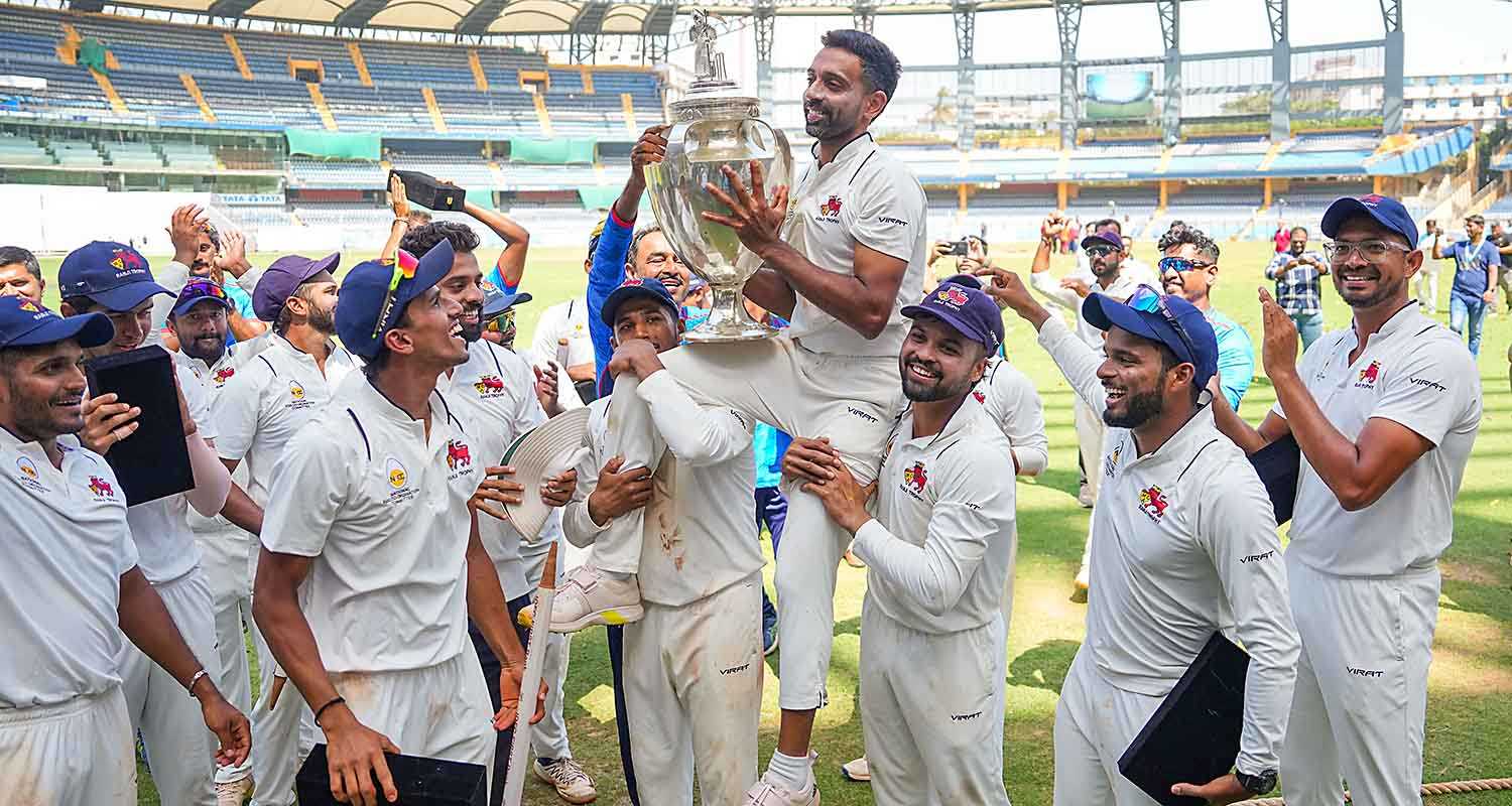 Mumbai's Dhawal Kulkarni lifts the championship trophy after winning the Ranji Trophy final test cricket match between Mumbai and Vidarbha as he played his last match, at the Wankhede Stadium, in Mumbai on Thursday.