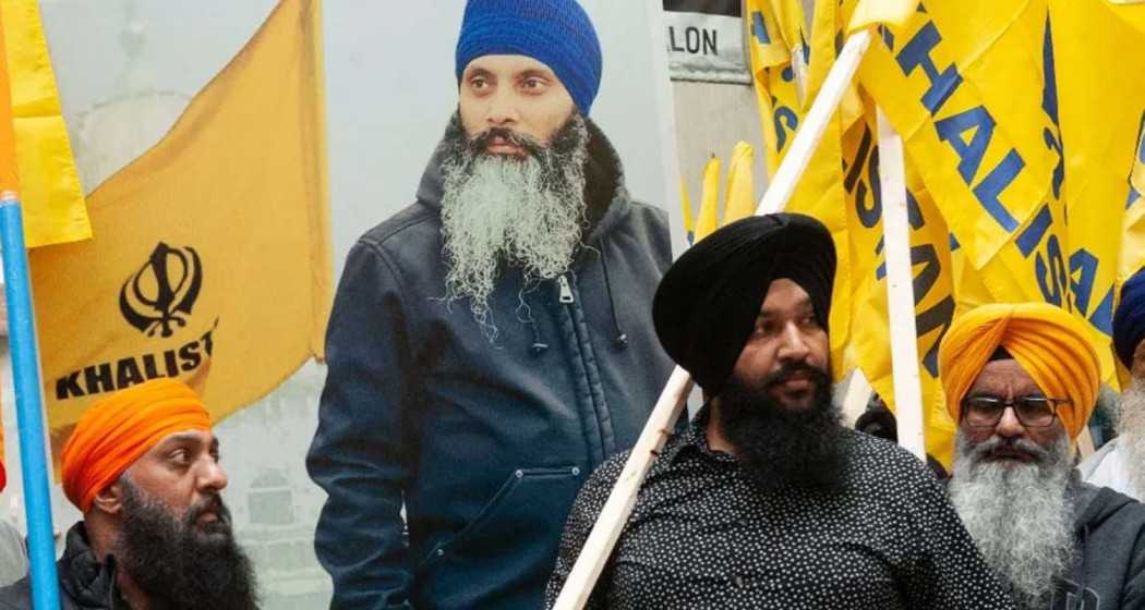 Khalistan supporters with a poster of Khalistan activist Hardeep Singh Nijjar in the background. 