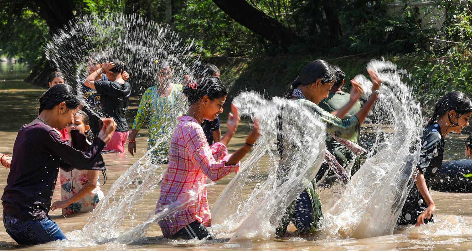 People bathe in the Ranbir canal during a hot summer day, in Jammu, Tuesday.