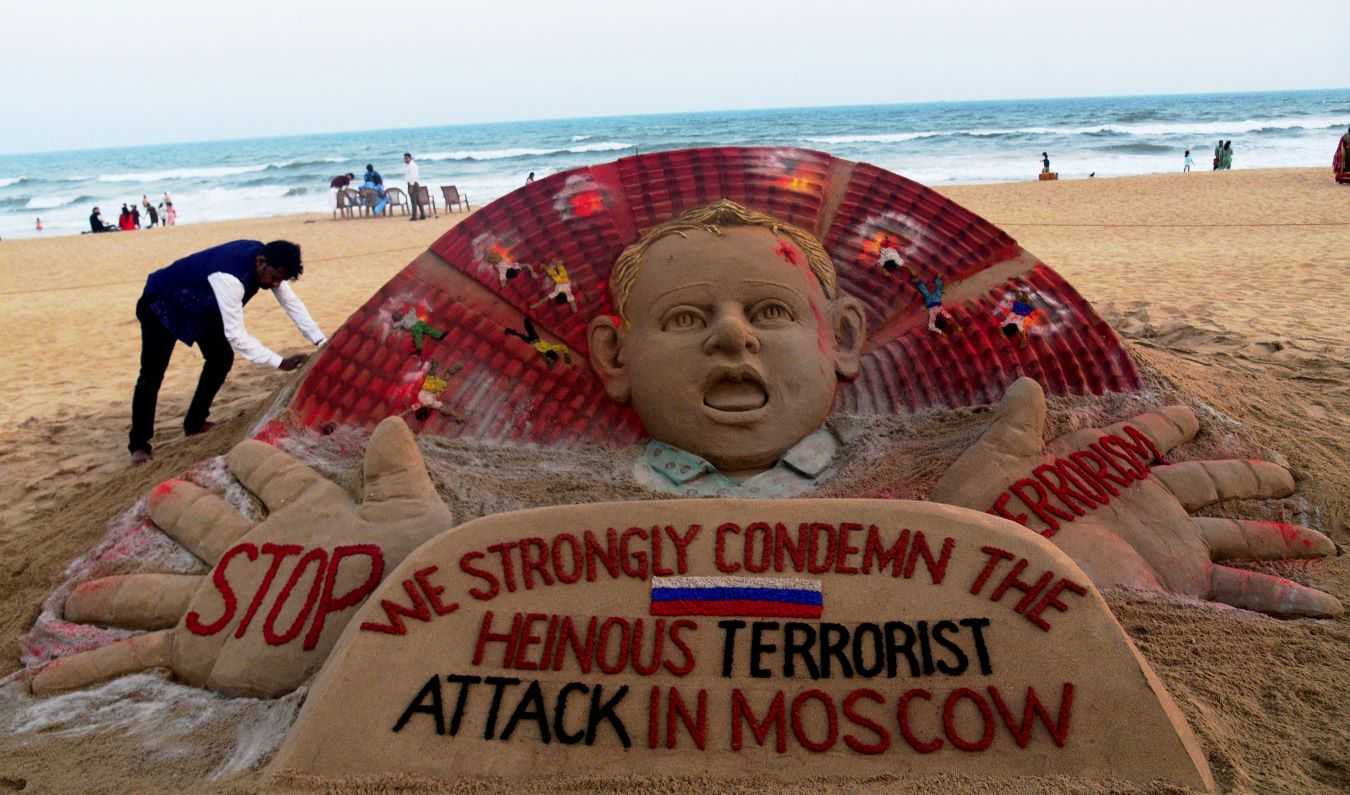 Artist Sudarsan Pattnaik at a beach in Odisha's Puri adding final touches to his sand sculpture condemning the Moscow concert hall attack. (PTI)