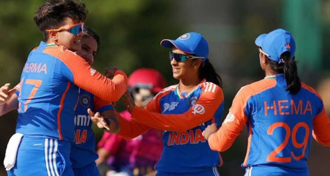 Indian women's cricket team members celebrate a wicket.