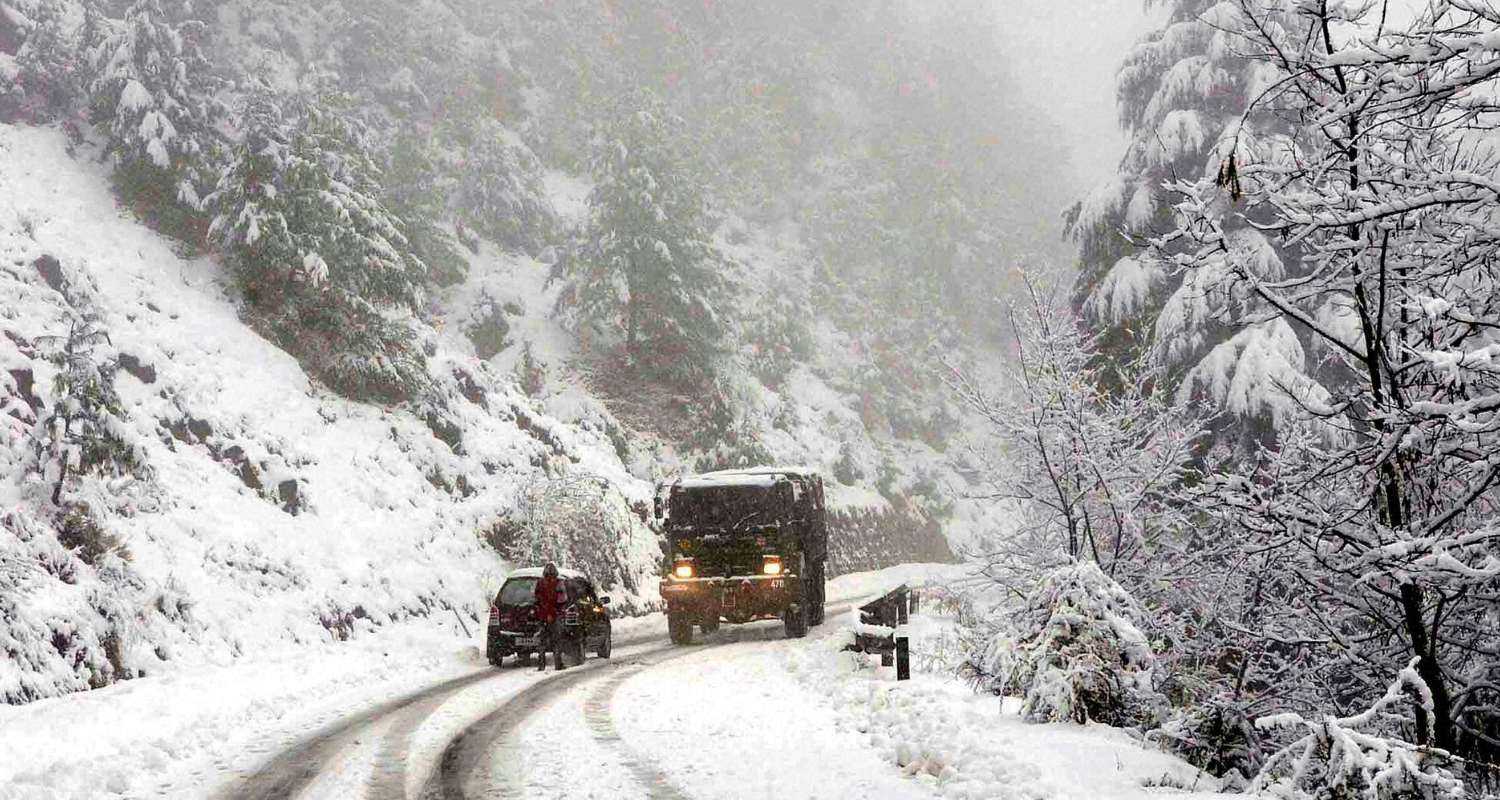 Vehicles treading on a snow laden road near Srinagar.