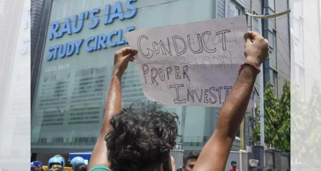 A student demonstrates in front of Rau's IAS Study Circle, demanding improved safety measures after recent tragic deaths.