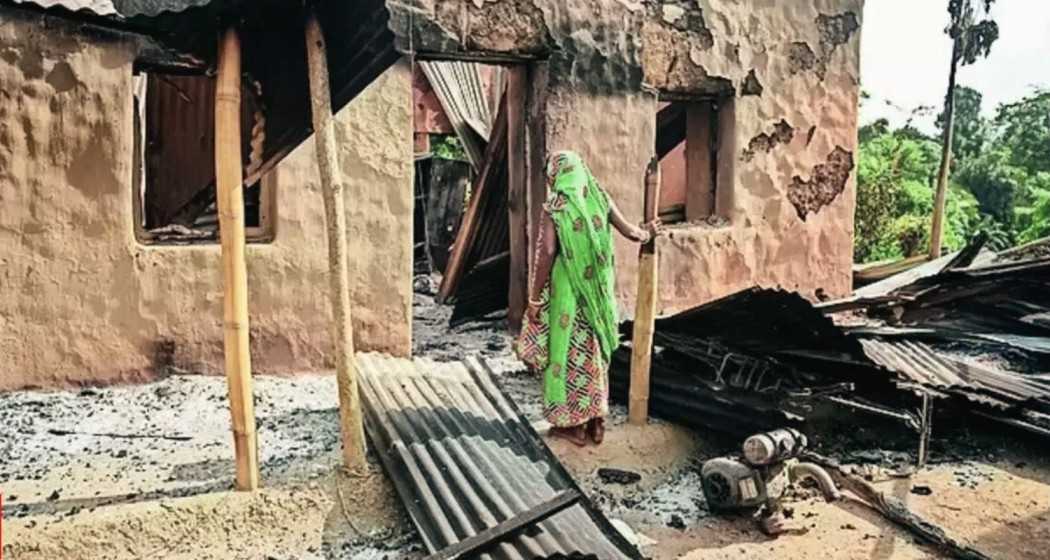 Aggrieved villagers search for belongings in the aftermath of mob violence in Tripura.