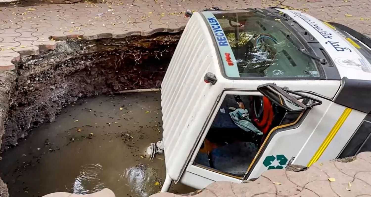 The civic sanitation truck fell backwards into the sinkhole, an official informed.