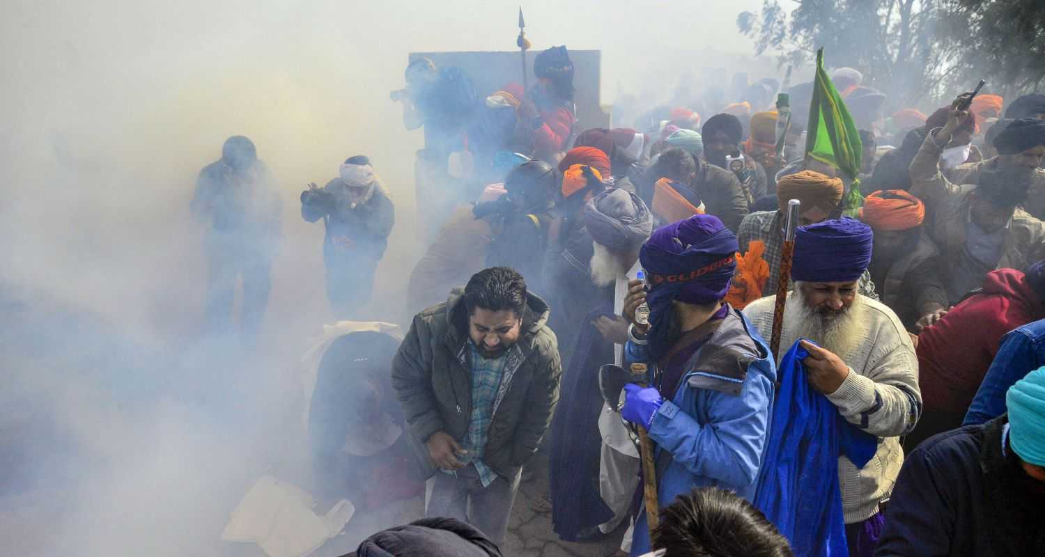 Farmers looking for cover as Police fired tear gas while 'Delhi Chalo' march.