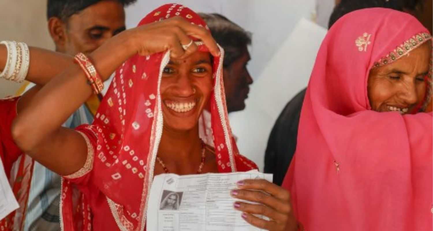 Voter smiles while casting vote.