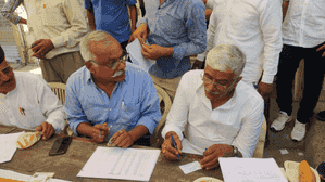 Union Minister Gajendra Singh Shekhawat makes voters' slips after casting vote in Jodhpur