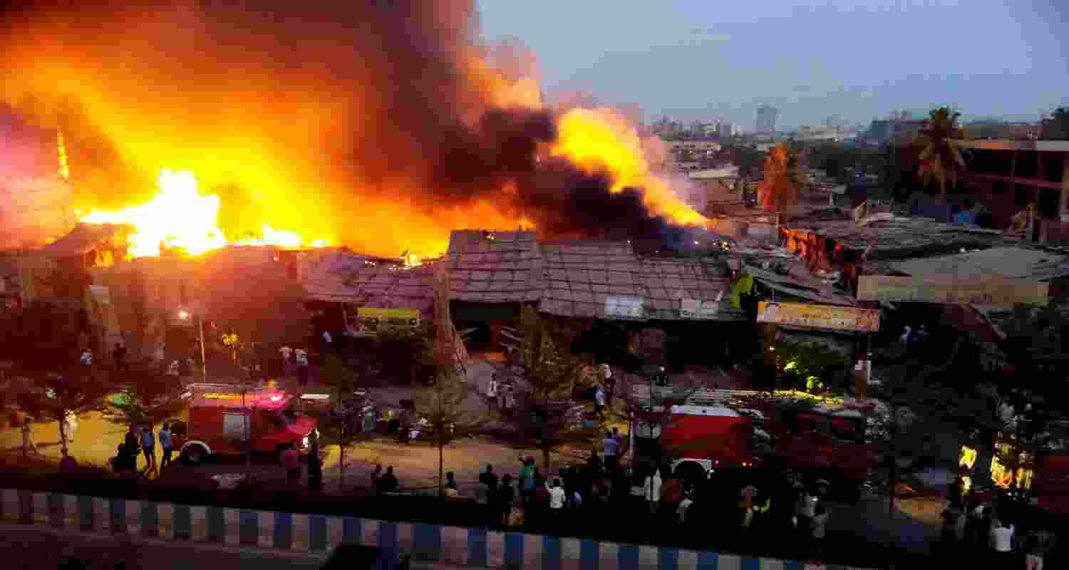 Firefighters at the spot after a fire broke out in a slum, at Bhayandar in Thane district. 