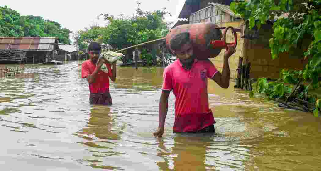 Villagers wade through a flood affected area, at Mayong village in Morigaon district on Tuesday, July 2, 2024.