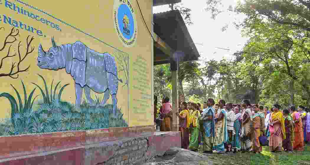 Voters wait in a queue at a polling station to cast their votes for the 2nd phase of Lok Sabha elections at a village in Baksa district of Assam, Friday, April 26, 2024.