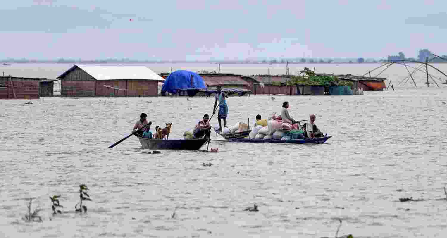 Villagers navigate floodwaters with belongings using a boat in Morigaon district, July 1, 2024.