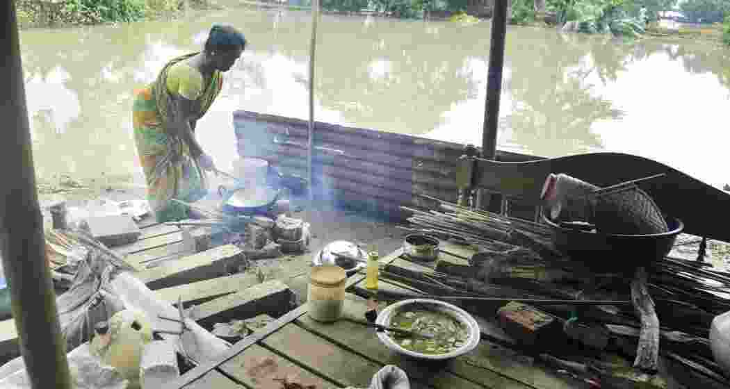 A woman cooks food at a flood affected village, in Morigaon district of Assam, Thursday, July 4, 2024. 