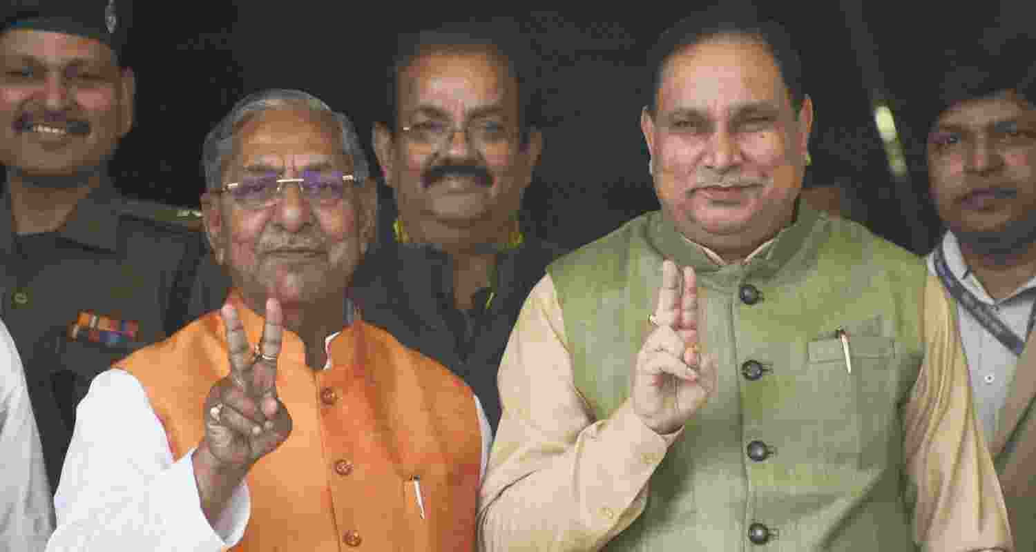 Newly elected Bihar Assembly Speaker Nand Kishore Yadav (C) and deputy Speaker Maheshwar Hazri show victory sign at State Legislative Assembly during the Budget session. 