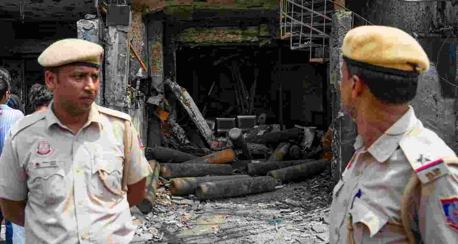 Cops stand at the site of the Delhi hospital fire.