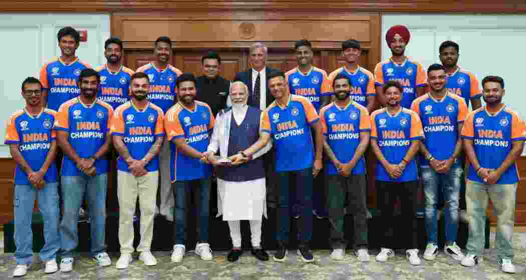 Prime Minister Narendra Modi posing with the trophy with the Indian Mens Cricket team at his residence in New Delhi on Thursday. 