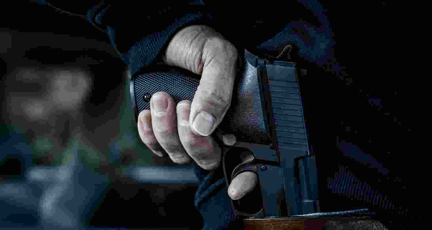 A man holds a pistol in his hand.