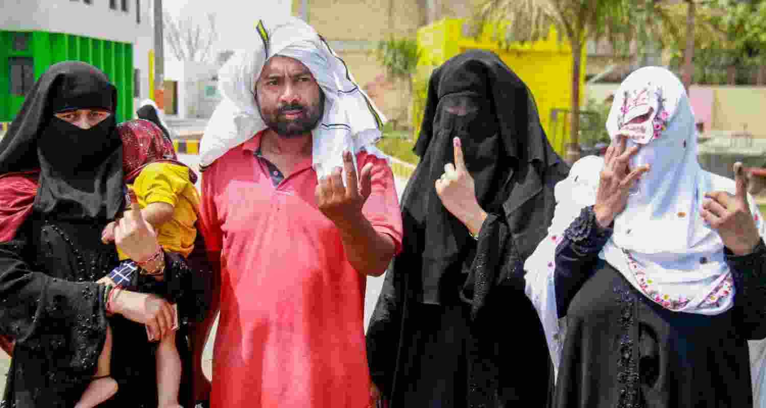 People show their ink-marked fingers after casting their votes for the sixth phase of Lok Sabha elections, in Nuh, Saturday. 