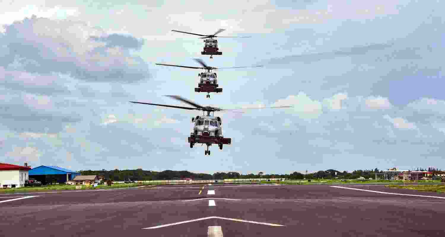 Three MH-60R Seahawk helicopters in a vertical formation above the runway at INS Garuda, signifying their imminent induction into the Indian Navy's air squadron.