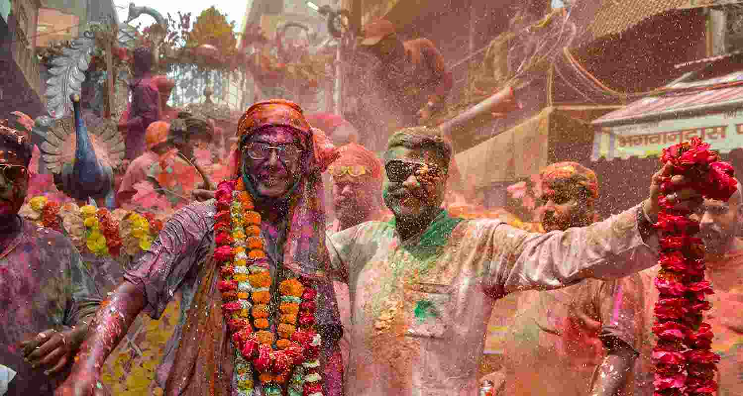 People play with colours ahead of the festival of Holi, in Agra