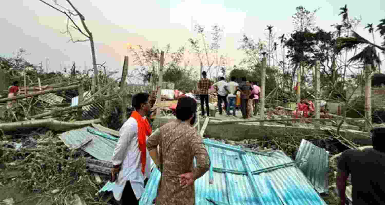 Houses are damaged and electric poles fell after a heavy storm that left at least five people dead, in Jalpaiguri, West Bengal, on March 31. 