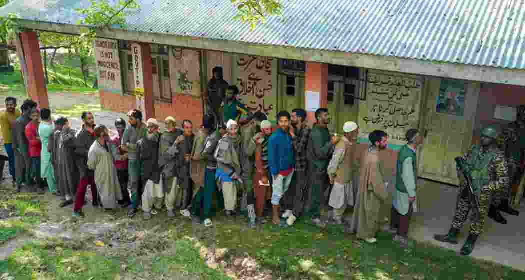 People wait in a queue to cast their votes at a polling booth during the sixth phase of Lok Sabha elections, at Noorbabad area in Kulgam district of South Kashmir on Saturday, May 25, 2024.