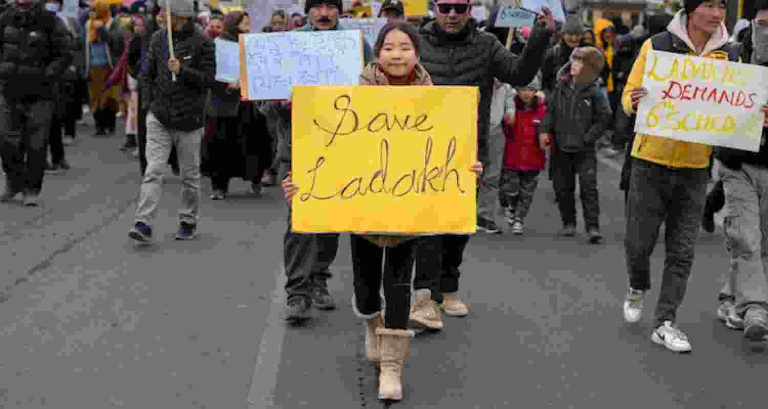 A child carries a sign during Ladakh Sixth schedule protests.