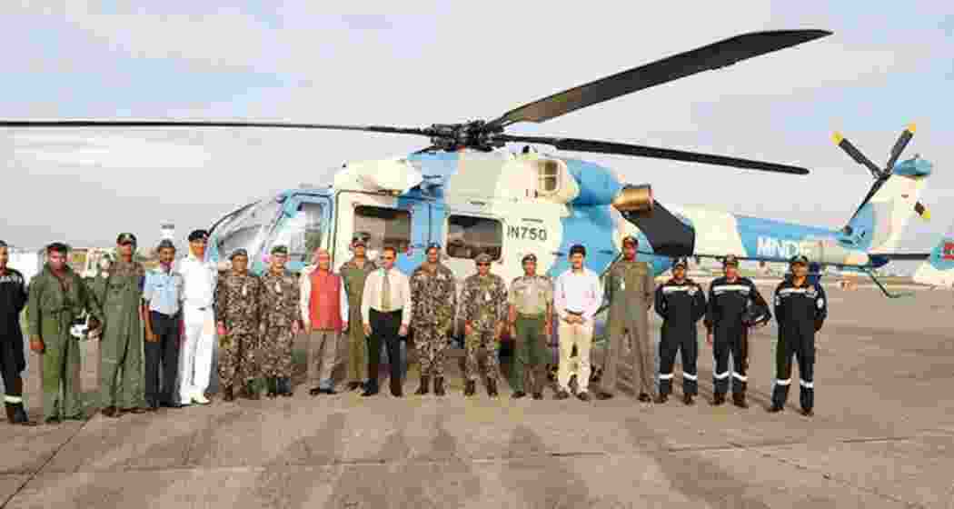 Indian military personnel pose with the helicopter gifted to the Maldives by India.