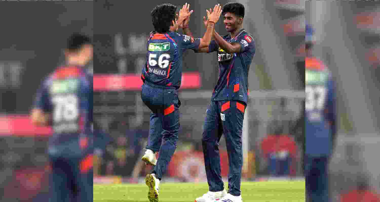 Mayank Yadav celebrates a wicket with co-bowler Ravi Bishnoi.