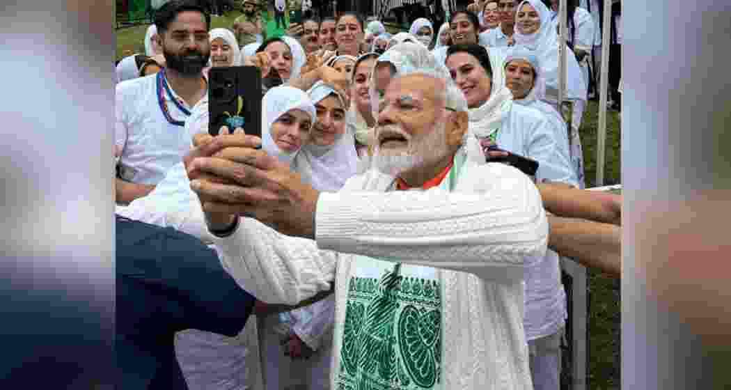 Prime Minister Narendra Modi clicking a selfie with participants of the International Yoga Day event in Kashmir's Srinagar on Friday.