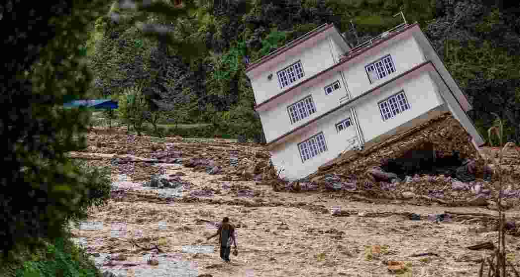 A man wades through the waters in the affected area of monsoon flooding in Roshi village of Kavre district, Nepal on September 30, 2024.