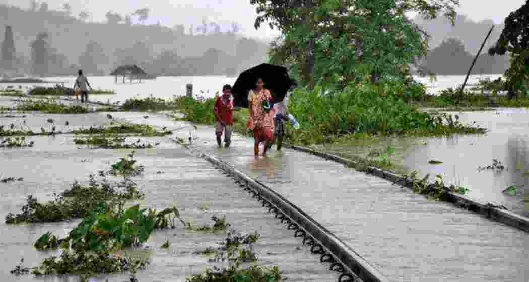 People walk on flooded railway tracks at Jokhalabandha in Nagaon district of Assam. Image for representative use only.