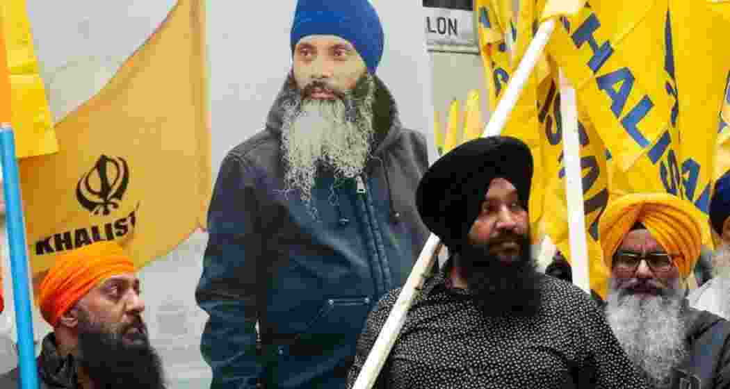 Khalistan supporters with a poster of Khalistan activist Hardeep Singh Nijjar in the background. 