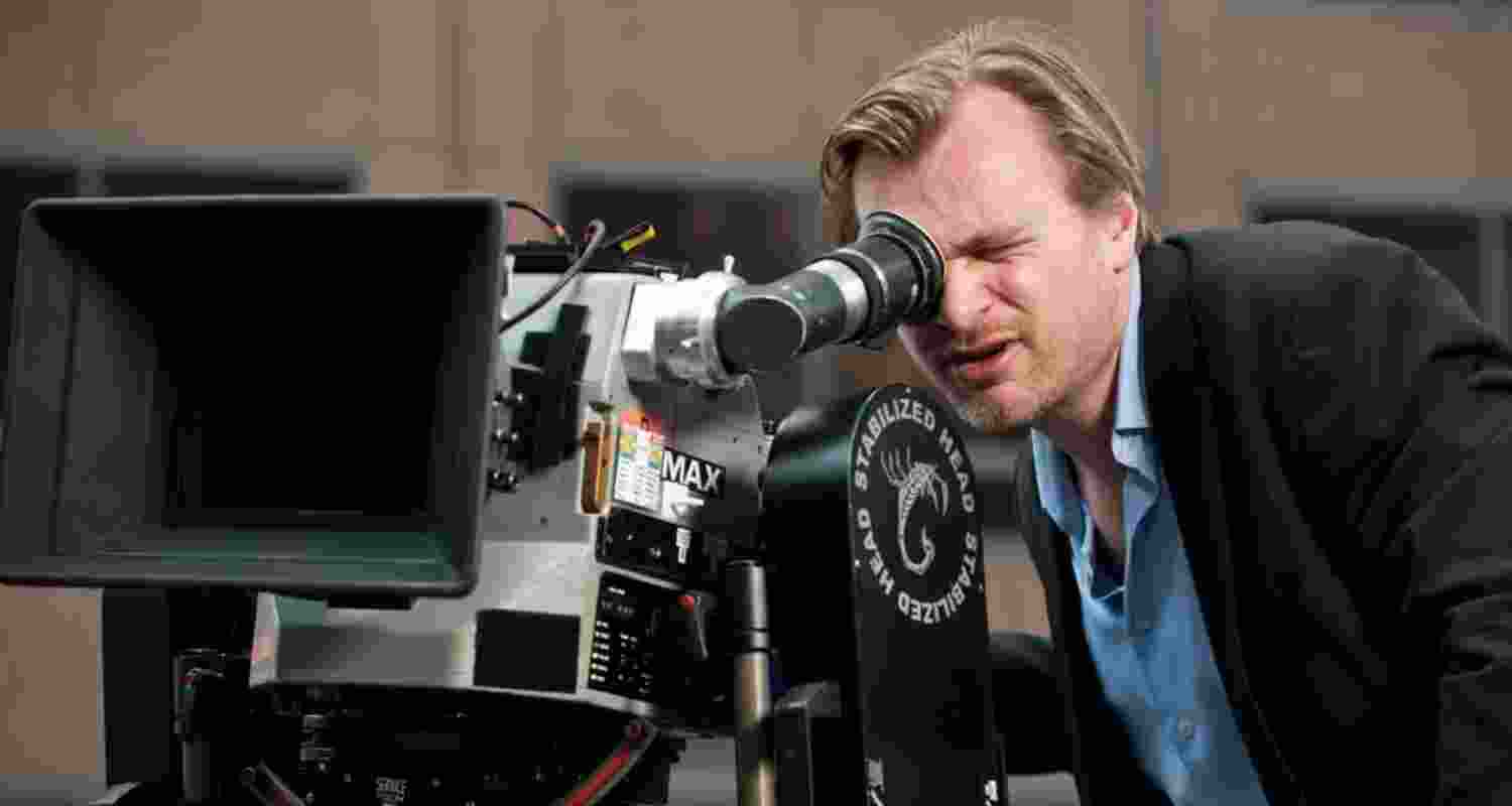 British Film Director Christopher Nolan looks through a camera's viewfinder during a shoot.