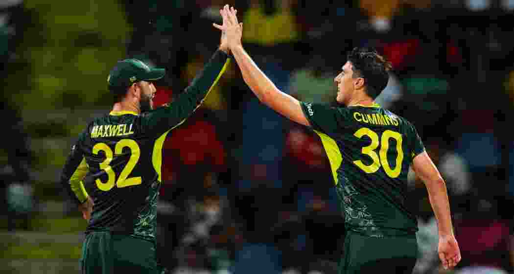 Australia's Pat Cummins, right, is congratulated by teammate Glenn Maxwell after taking the wicket of Bangladesh's Mahmudullah during the ICC Men's T20 World Cup cricket match between Australia and Bangladesh in North Sound, Antigua and Barbuda, Thursday, June 20, 2024