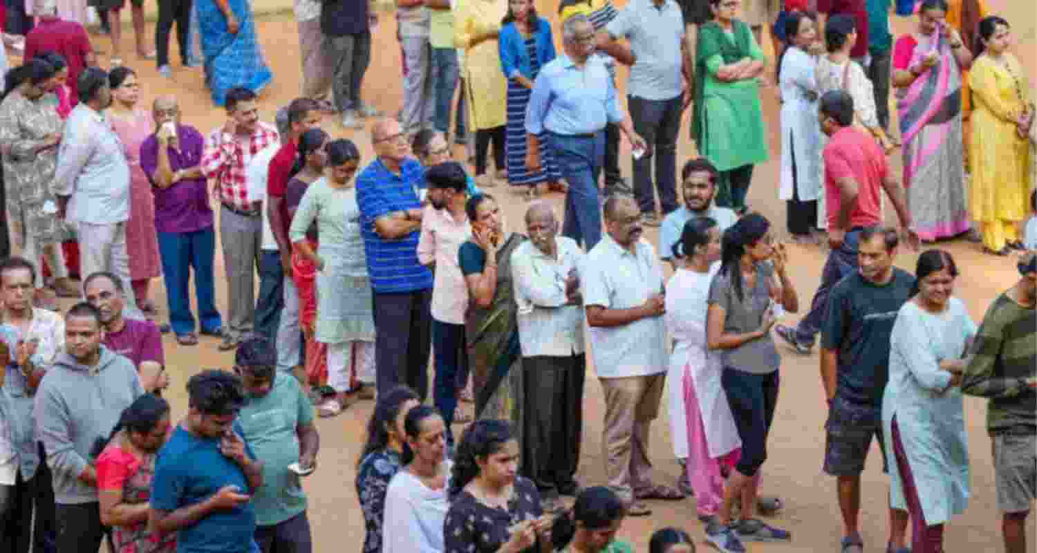 People stand in queue to cast vote.