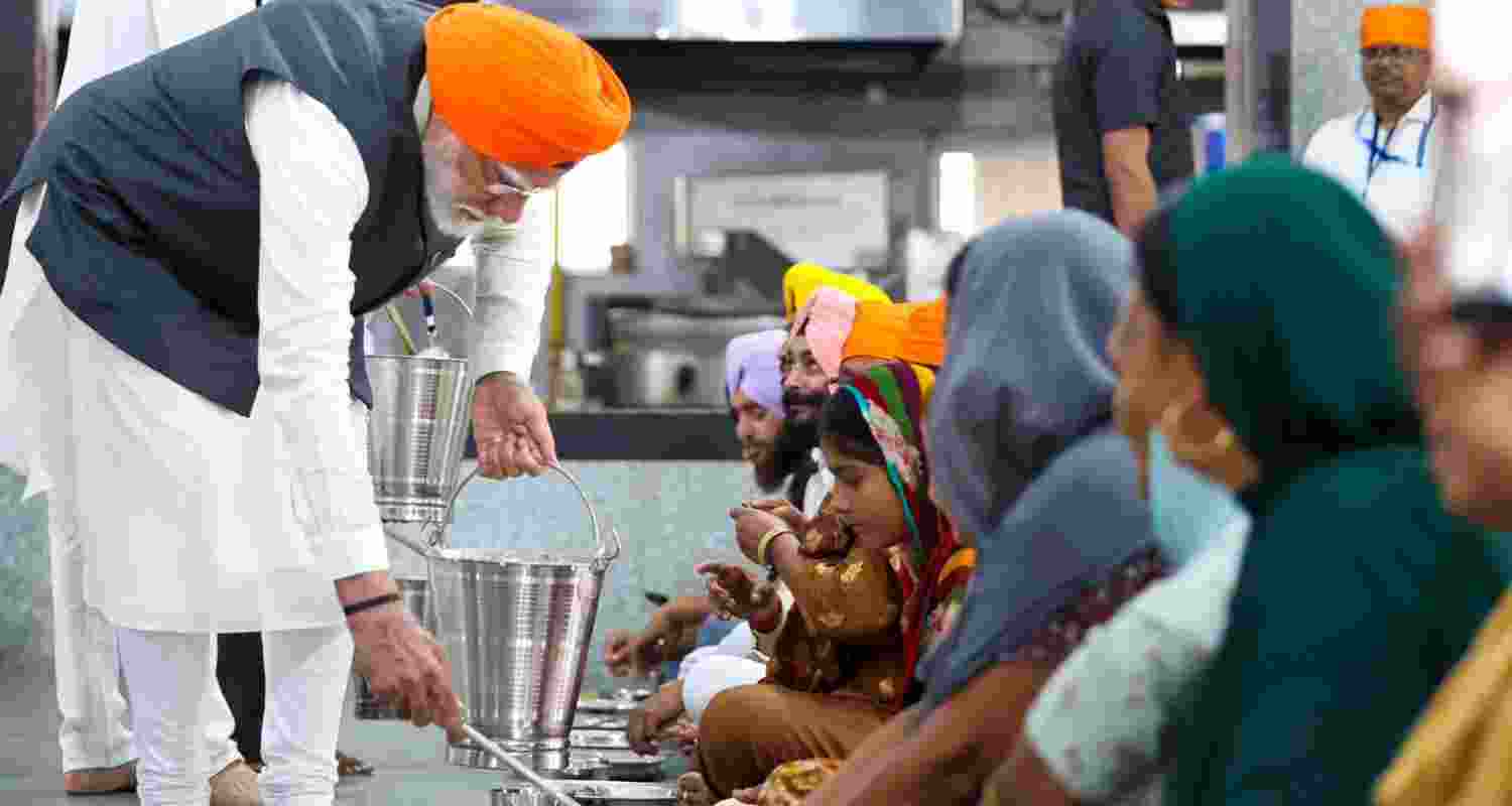 Prime Minister Narendra Modi serving food at the Gurdwara. 