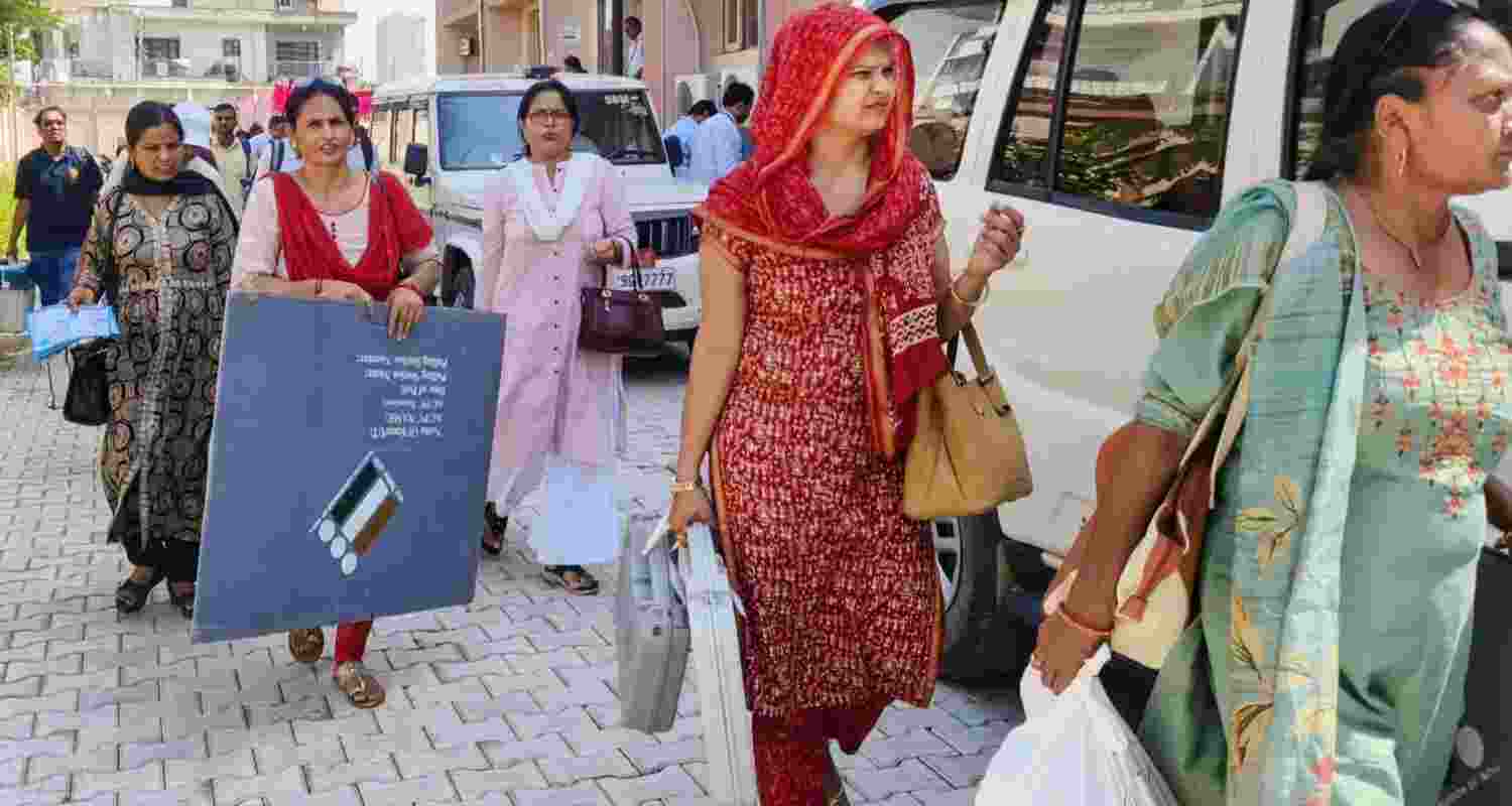 Faridabad: Polling officials leave for their their respective polling stations on the eve of the Haryana Assembly elections, in Faridabad district. 