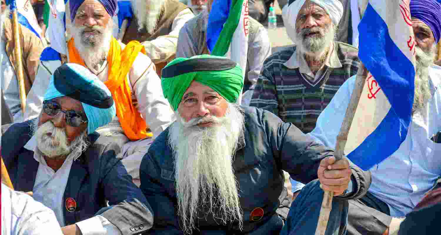 A  group of Sikh farmers sitting at the Khanauri border, wearing black bands on their turbans as a protest against Shubhkaran Singh's death.