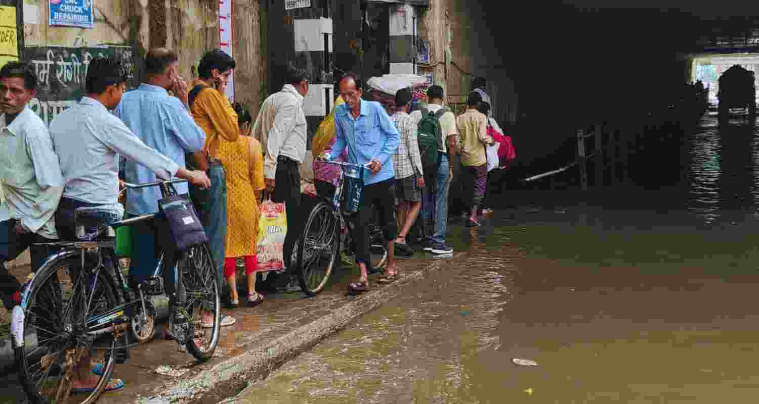 Commuters wade through a waterlogged Old Faridabad underpass after heavy rain, in Faridabad, Thursday, August 1. 